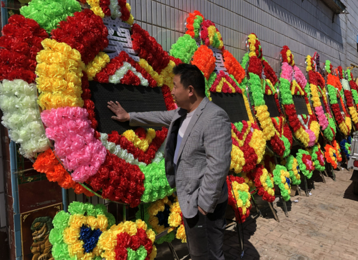 ▲3月21日，冯大伟站在院外等着新最好的电子花圈发货。新京报记者 张静姝 摄