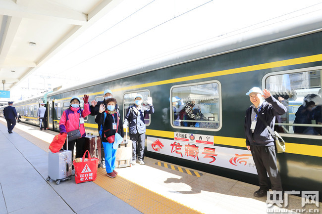 “龙藏号”旅客在列车前合影留念。原勇 摄