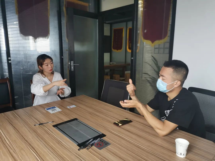 谭婷与来律所求助的聋人沟通。受访者供图