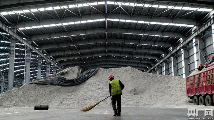 　　图为昌吉市三工镇象道物流4号线铁路仓库，工人正在对对棉花籽进行打包备用。 杨健 摄  央广网发