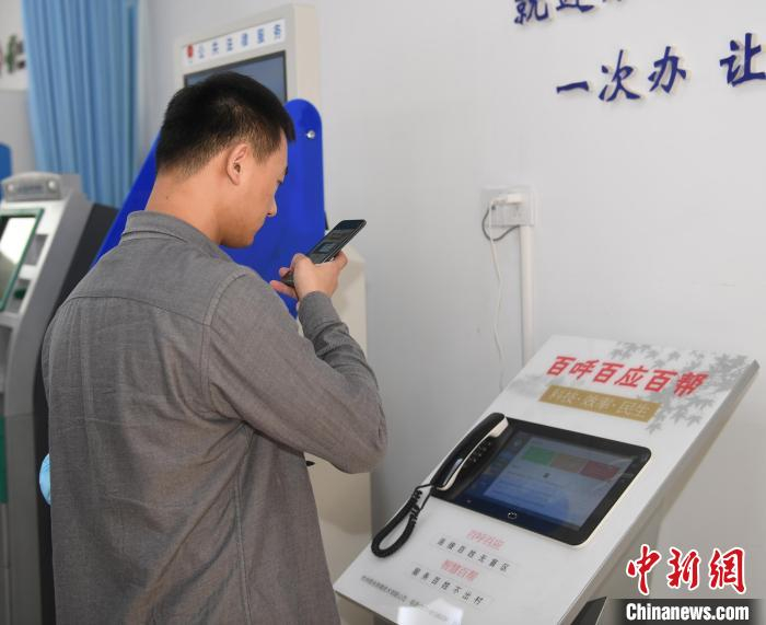 图为：参观者在拍摄枫源村连接村民的智能呼叫设备。　王刚 摄