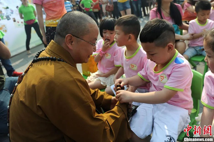 资料图：图为罗汉寺素全法师与参加生日party的孩子。张浪 摄