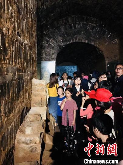图为讲解员为游客讲述古墓的前世今生。　洛阳古代艺术博物馆供图