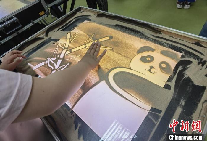 图为学生用沙子创作竹子和大熊猫。　高展 摄