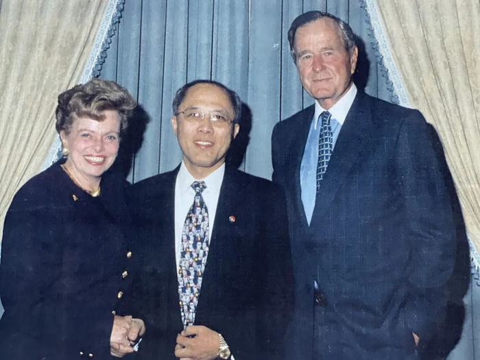 莫天成（中）与老布什（右） 等合影。受访者供图