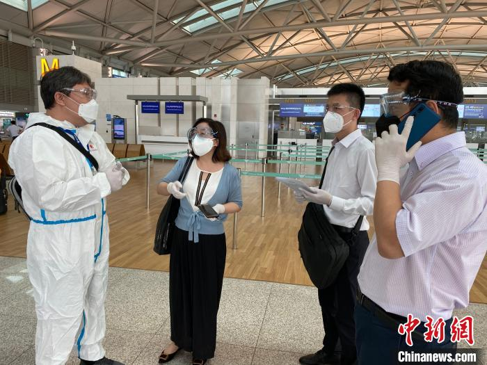 中国驻韩国大使馆工作人员在机场为旅客协调临时航班乘机。　中国驻韩国大使馆供图