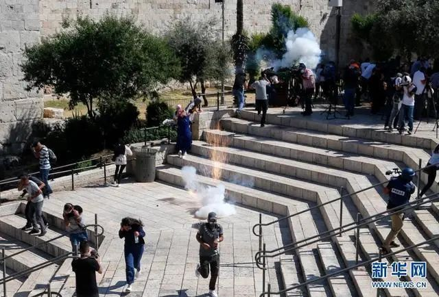 ↑5月18日，巴勒斯坦民众在耶路撒冷躲避以方发射的震爆弹。图据新华社