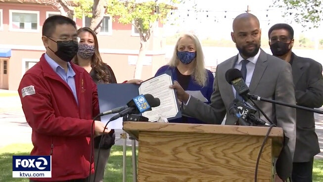 索普（右）与当地华人社区代表展示道歉声明 视频截图