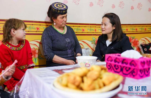 在阿勒玛勒克村，陈芳莹（右）在学生再努热·沙拉依丁（左）家中进行家访（5月12日摄）。新华社记者 胡虎虎 摄