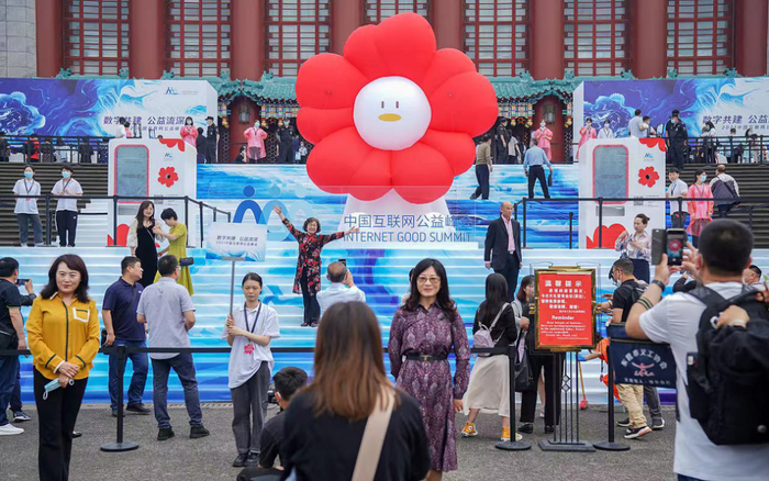 ▲在峰会现场外场，巨型“小红花”颇受市民欢迎