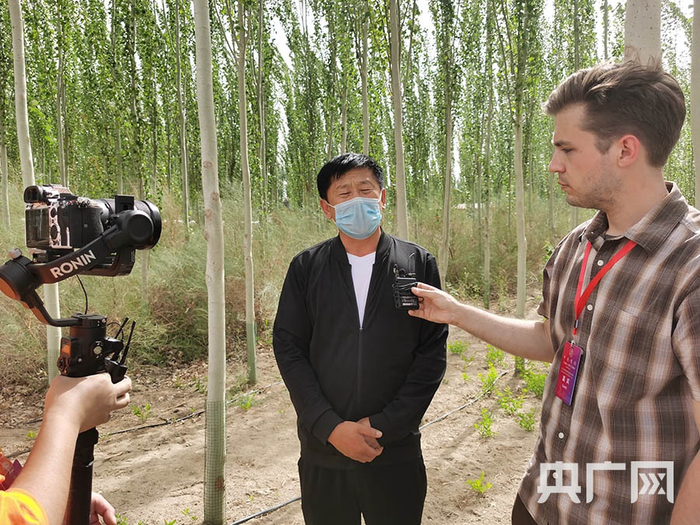 麦盖提县治沙中心主任殷红海介绍通过治沙，带动受益。央广网发