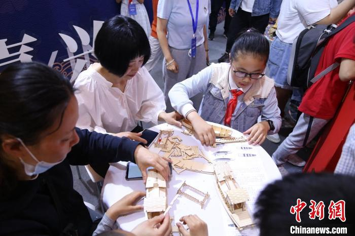在教博会长三角协作育人展区，学生们正在嘉兴市教育局展位体验红船打造和制作。　上海市教委供图