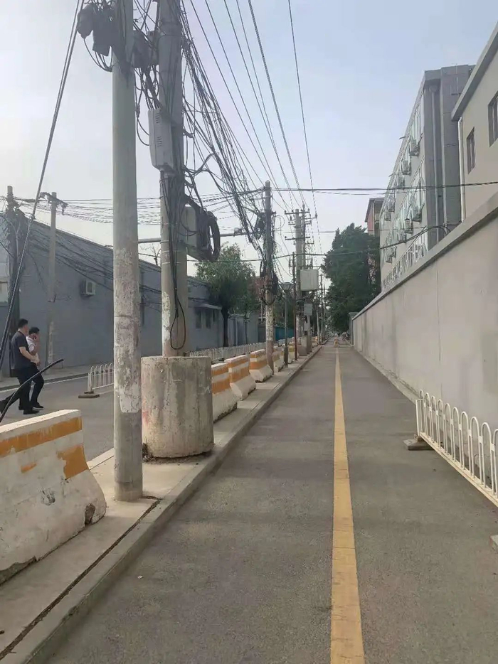 ▲5月23日，朝阳区官庄路，被路中央的20余个电线杆“一分为二”，一侧是双向行驶的机动车道，另一侧是双向行驶的非机动车道。新京报记者 张静姝 实习生 陈玖阳 摄