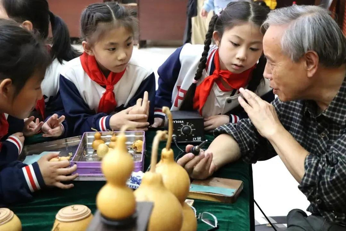 传承人正在现场制作“葫芦烙画”（央广网发 渝中区中心路小学供图）