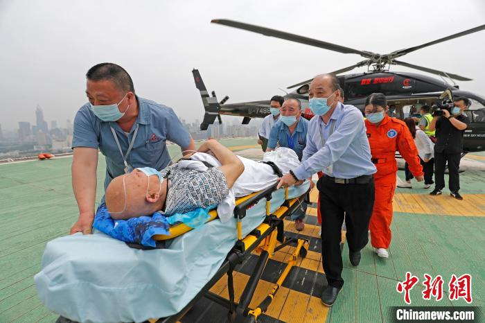 医护人员将患者从新空医疗救援直升机转运至门诊大楼。　殷立勤 摄
