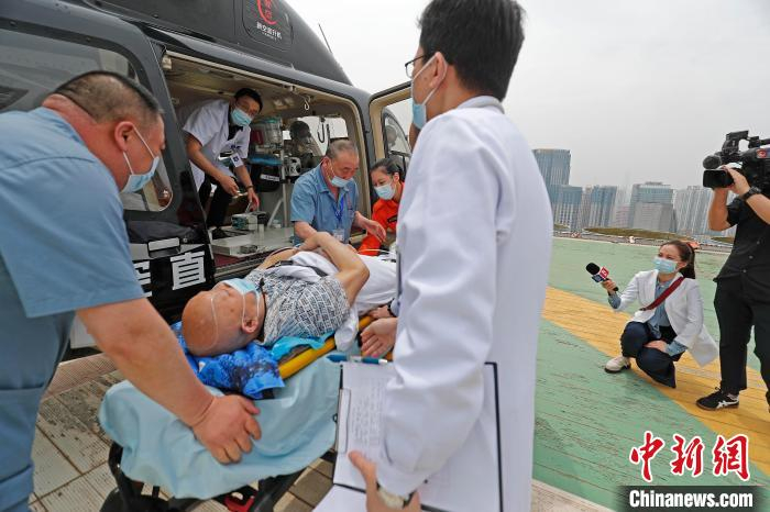 医护人员将患者从新空医疗救援直升机转运至门诊大楼。　殷立勤 摄