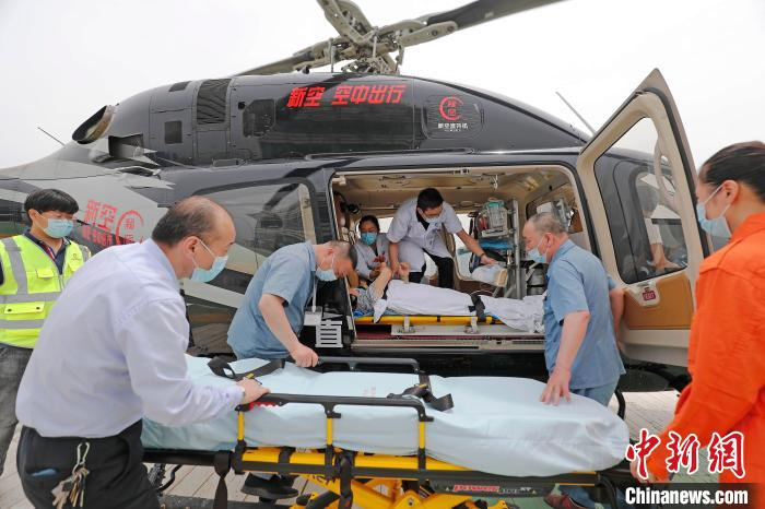 医护人员将患者从新空医疗救援直升机转运至门诊大楼。　殷立勤 摄