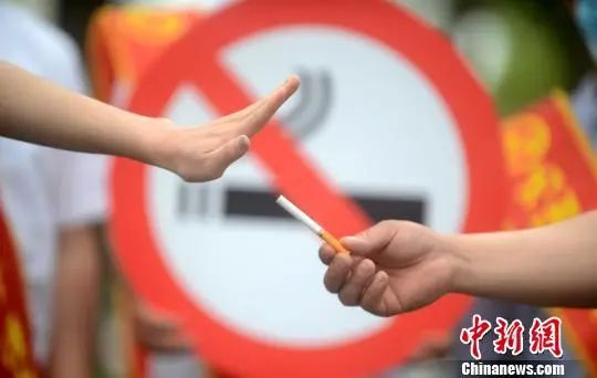 图为控烟志愿者在街头用行为艺术劝市民戒烟。孟德龙 摄