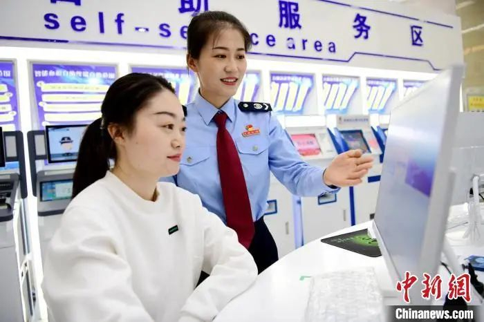 资料图：青海税务部门工作人员协助纳税人缴费人办理业务。国家税务总局青海省税务局供图