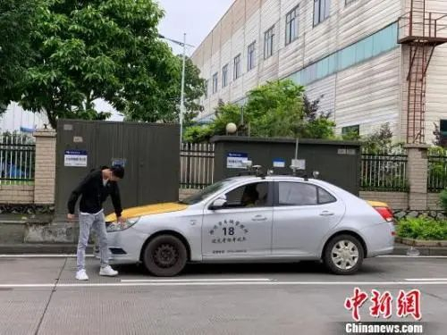 资料图：一名考生在登车前进行绕车检查。王以照 摄