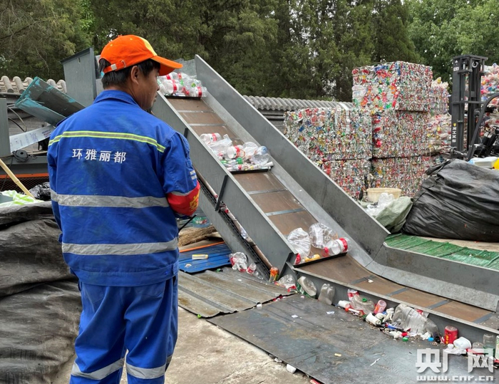 北京西城区一处可回收物中转站，处理设备旁边堆放着经过压缩的塑料瓶和易拉罐（总台央广记者 白杰戈 摄）