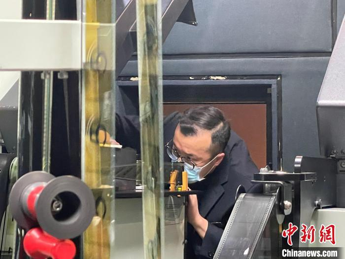 上海科技馆上映最后两部胶片科普电影，工作人员将胶片装上放映机片道。　郑莹莹 摄