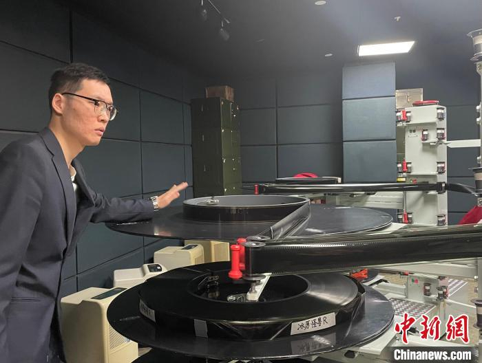 上海科技馆上映最后两部胶片科普电影，工作人员将胶片装上放映机片道。　郑莹莹 摄