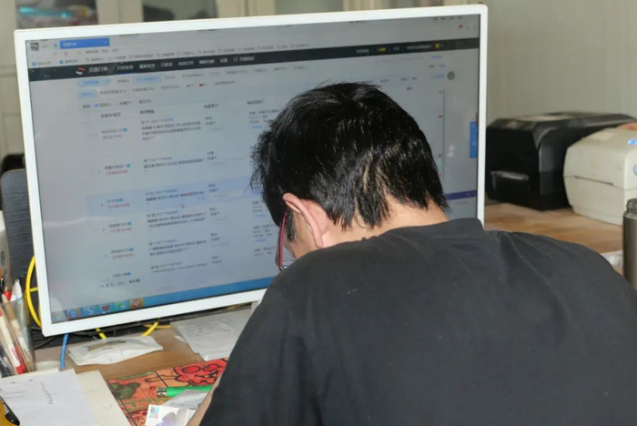 ▲徐伟在电脑前处理订单，手机上处理客服工作。接连十几天每晚两点睡觉，早晨六点起床，有时候一天下来，脑子连“3+2”等于几都要反应好一阵。