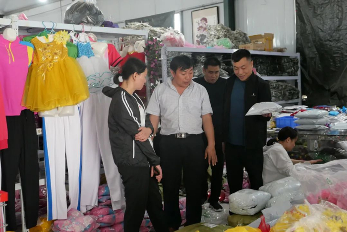 ▲河南西平县商务局局长郭丽（左一）来到丁楼村支部书记任庆生（左二）家的公司学习电商经验。西平县是服装外贸生产基地，上个世纪八十年代，服装业便在当地兴起，当地人多从事品牌衣服代加工的下游产业，她希望能带领当地企业转型做上游销售产业，毕竟品牌服装代加工是低端市场，不仅利润微薄，而且还面临招工难的问题。