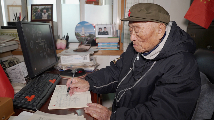 ▲97岁高龄的张文辉在电脑上为记者展示过去采访画面
