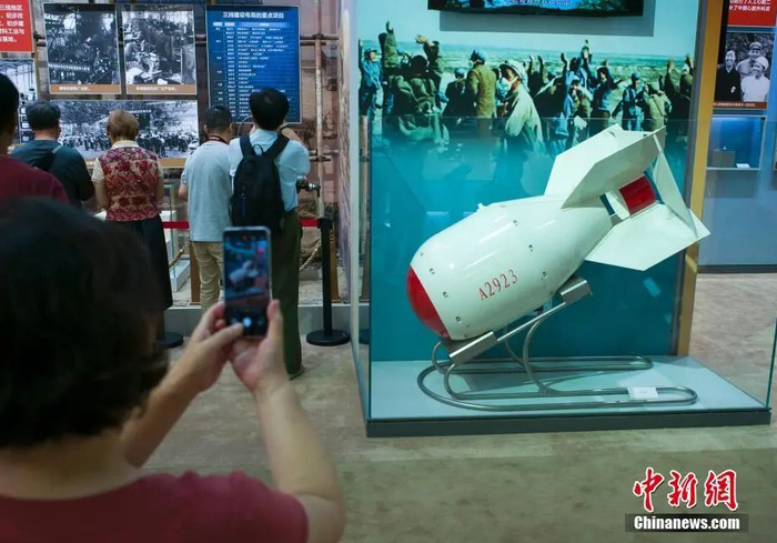 资料图：在“伟大历程 辉煌成就——庆祝中华人民共和国成立70周年大型成就展”上，参观者拍摄新中国第一颗原子弹模型。中新社记者 侯宇 摄