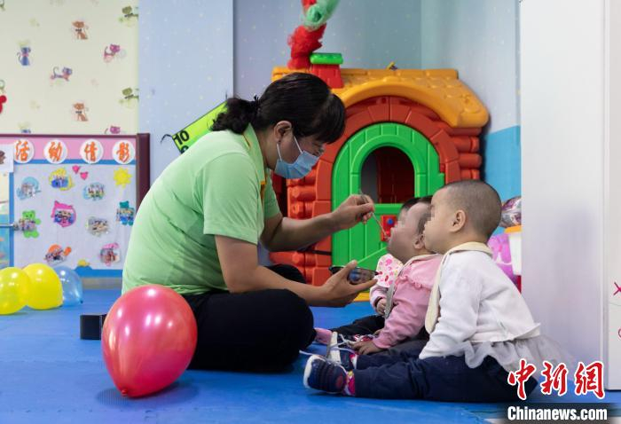 “护理员妈妈”正在给孩子们喂饭。　杨迪 摄