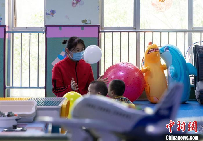 “护理员妈妈”陪孩子们玩耍。　杨迪 摄