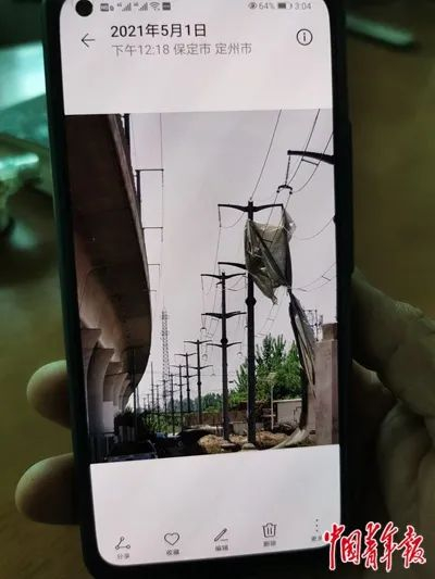 村民用手机拍摄到塑料布挂在供电线上。