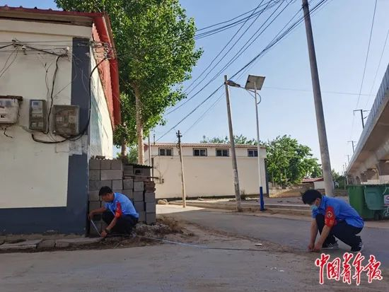 铁路巡防员在测量一处彩钢房到高架桥的距离。