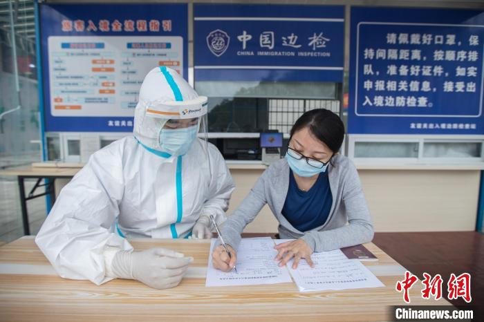 民警在友谊关口岸对入境人员进行证件信息核查。　梁箫 摄