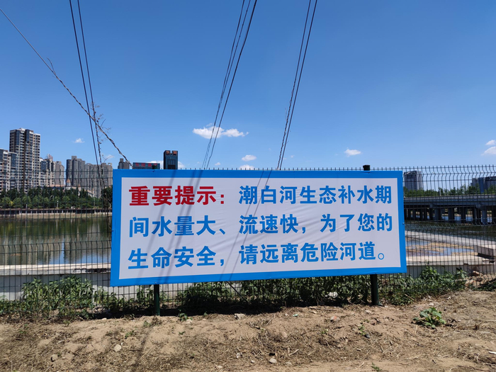 潮白河白庙橡胶坝附近的补水安全提示标语。 新京报记者 赵敏 摄