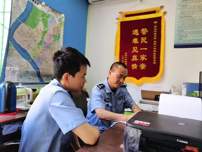 罗威认真学习师父吴立峰的社区工作方法（央广网发 江北公安分局供图）
