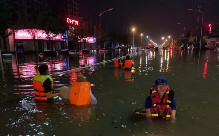 　▲濮阳市红十字救援队队员带被困市民走出积水区域。受访者供图