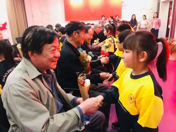 图说：小朋友为老党员送小红花
