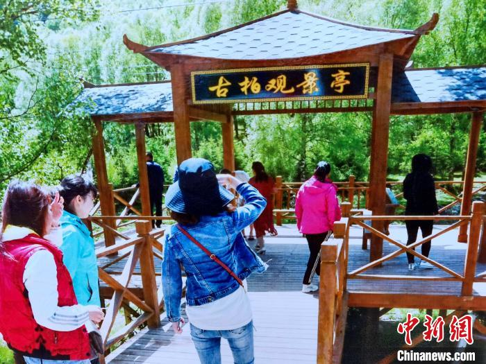 图为游客到扎碾公路建设过程中打造的景观游玩。　李隽 摄