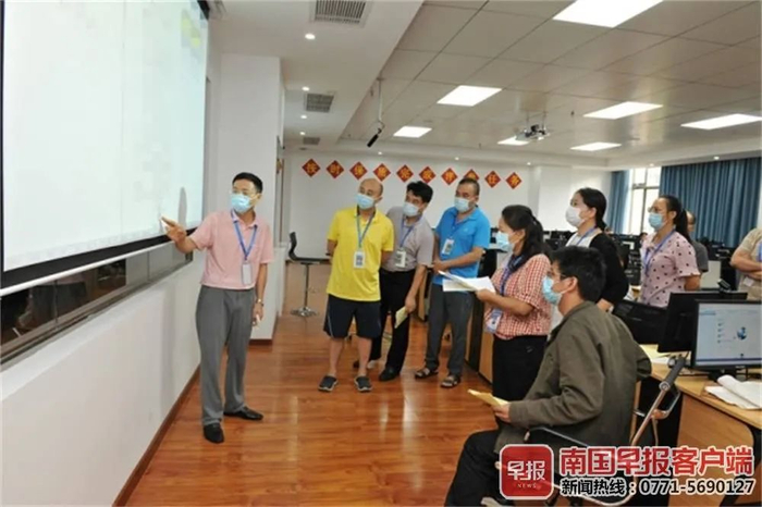 ▲学科评卷组正在认真制定评分细则。