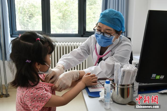 郑宝英正在给患儿看诊 中新网记者 翟璐 摄