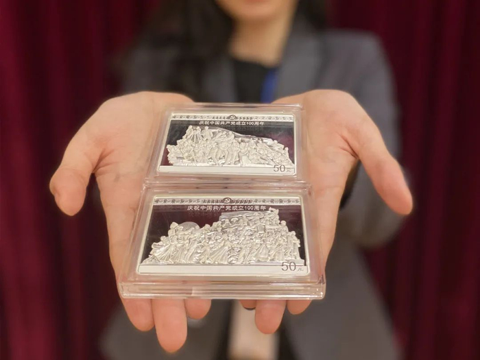 ▲一名金币总公司员工向记者展示两枚150克银币。新华社记者吴雨 摄