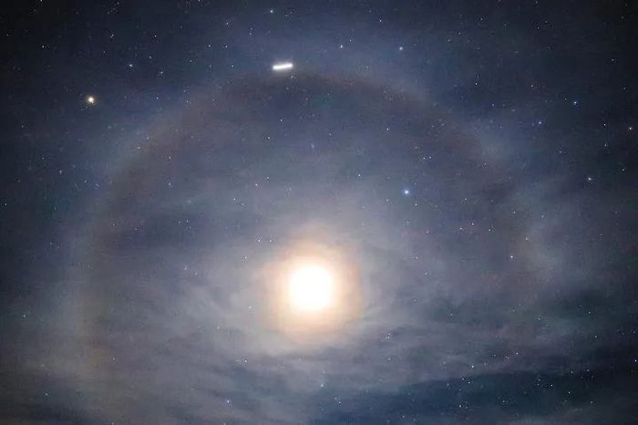 北京市天文爱好者王俊峰2019年12月22日在云南红河拍摄的ISS飞越月晕的照片。（本人供图）