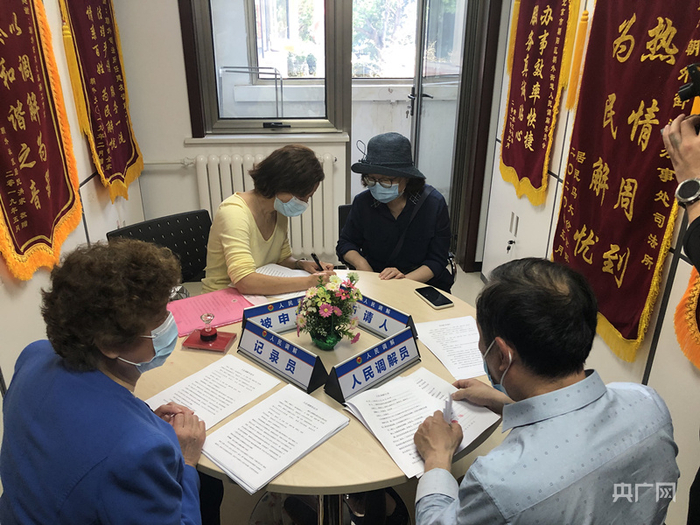 任建友（左一）现场调解家事纠纷（央广记者孙莹 摄）