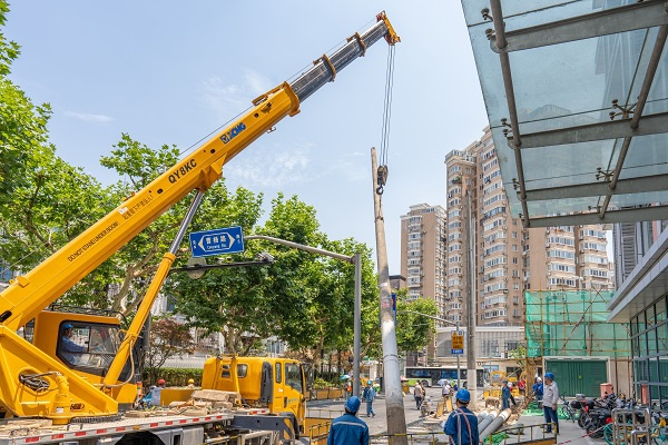 图说：施工人员拔除原来的架空线电杆  （下同）