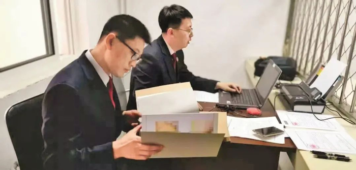 陈实（左）认真地翻看着卷宗。（图片来源：受访者供图）