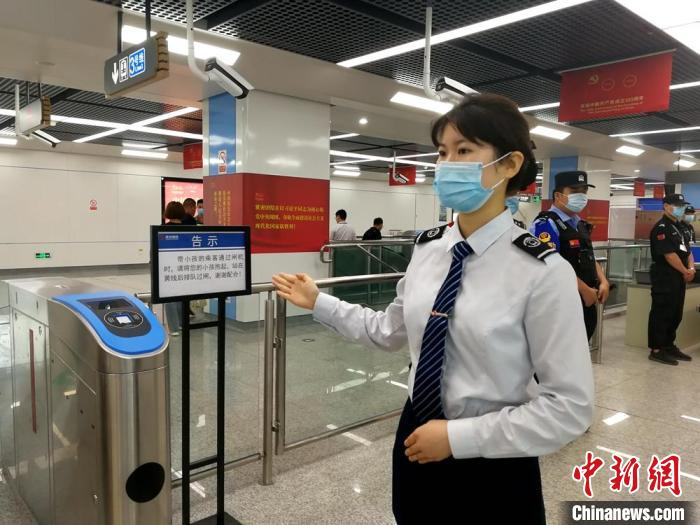 地铁乘务人员规范服务，欢迎首批乘客到来。　朱志庚 摄