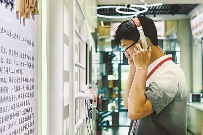 昨天，市民在上海国际时尚中心党群服务站内，戴上耳机聆听上海港码头号子。黄尖尖 摄